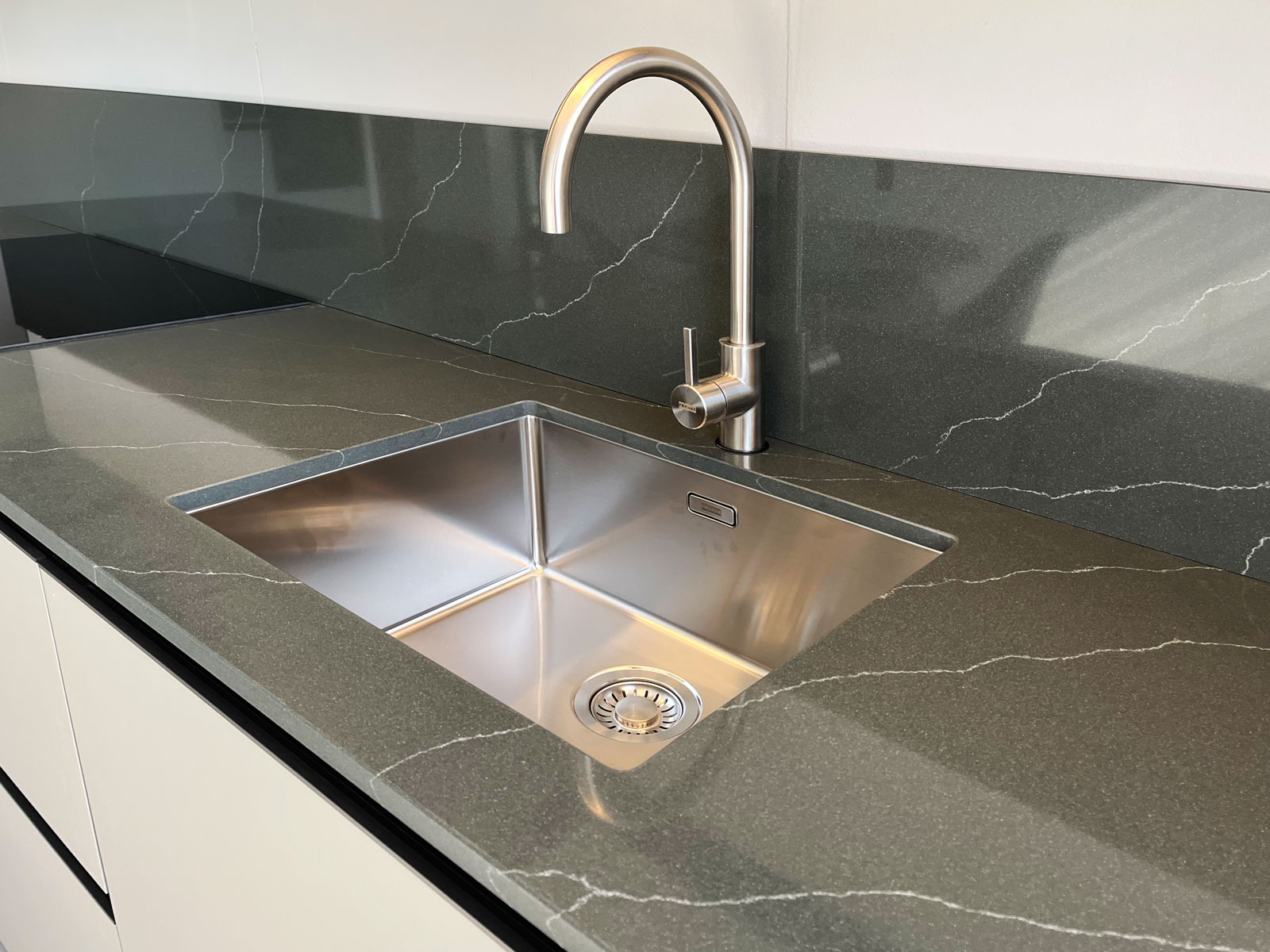 Stone Italiana Cosmolite Materiale Ecosotenibile Cucina Venantis Green Artemis Top Paraschizzi Verde Vena Passante Dettaglio Con Lavandino Piano Induzione